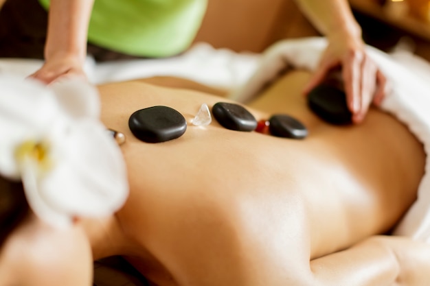 Young woman having a hot stone massage therapy