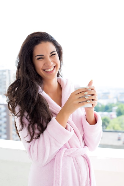 Young woman having a morning coffee on terrace