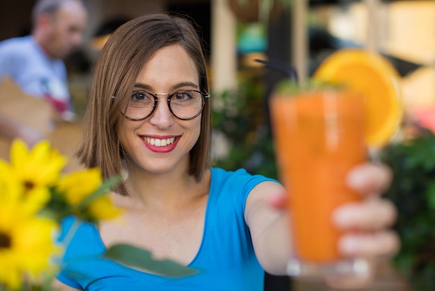 Foto giovane donna con un succo d'arancia