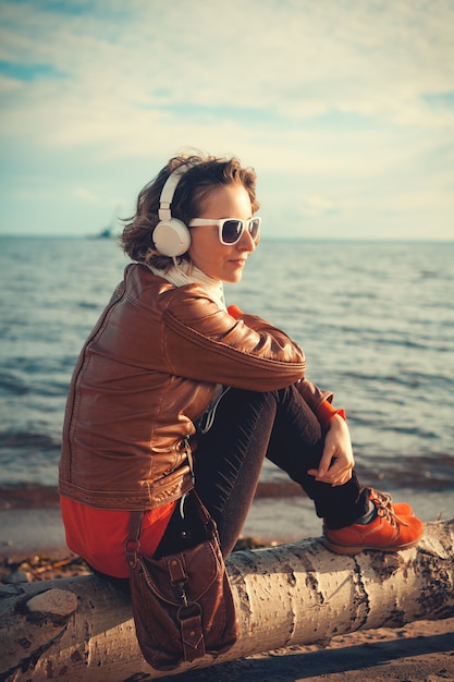 Young woman in a headphones at the beach