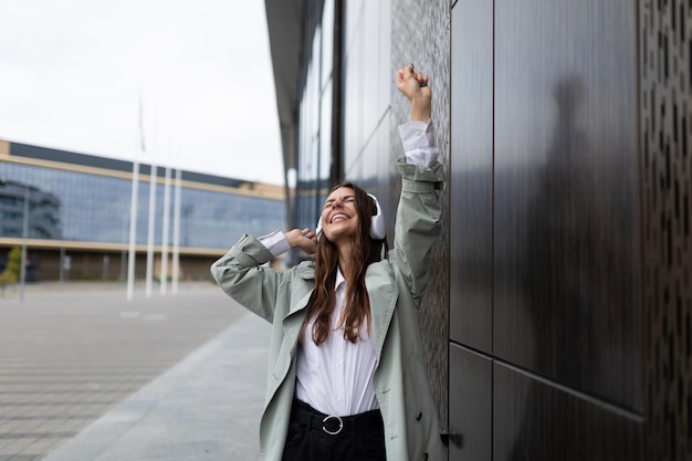 Young woman in headphones dancing in the city