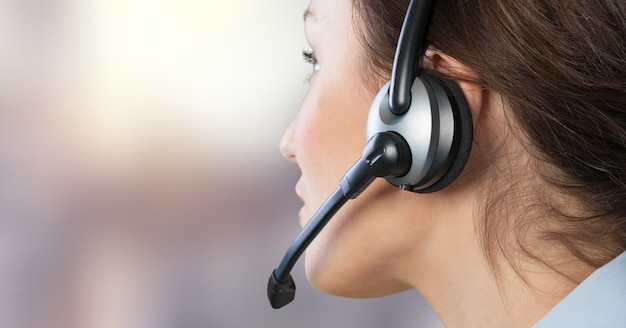 A young woman in headphones with a microphone working in a call center