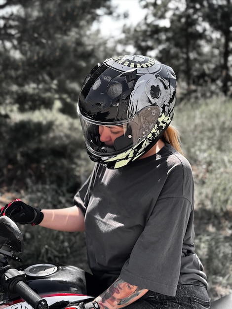 Foto giovane donna con casco e guanti su una motocicletta