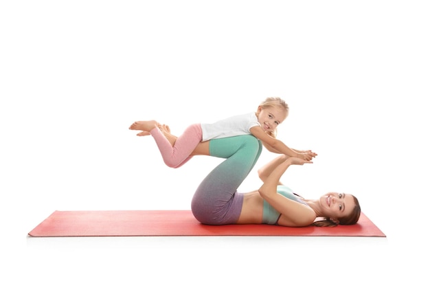 Young woman and her daughter doing exercise isolated on white Home fitness