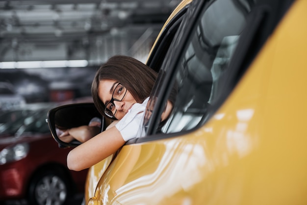 Young woman in her new car smiling