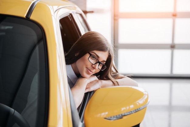 Giovane donna nel suo nuovo sorridere dell'automobile