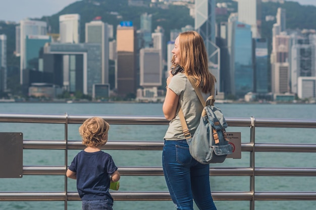 若い女性と彼女の息子は、香港、中国のビクトリアハーバーの写真を撮っています。