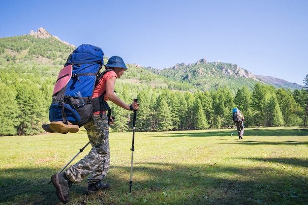 Young woman hiker on a sunny day trekking in high mountains