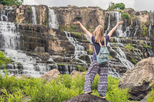 젊은 여성 등산객, Amazing Pongour Waterfall의 배경에 있는 관광객은 베트남에서 가장 유명하고 아름다운 가을입니다. 달랏 시에서 멀지 않은 45km. 베트남 달랏.