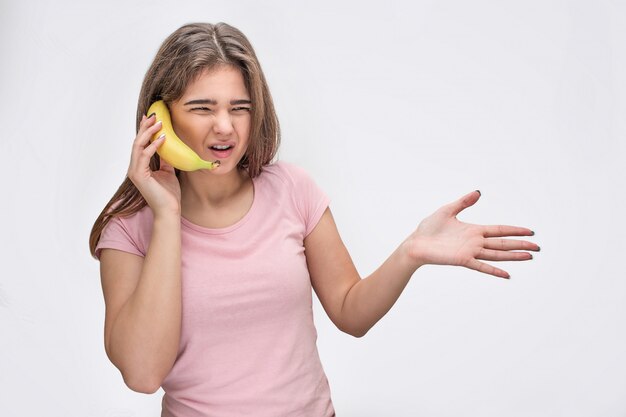 Young woman hold banana instead of phone