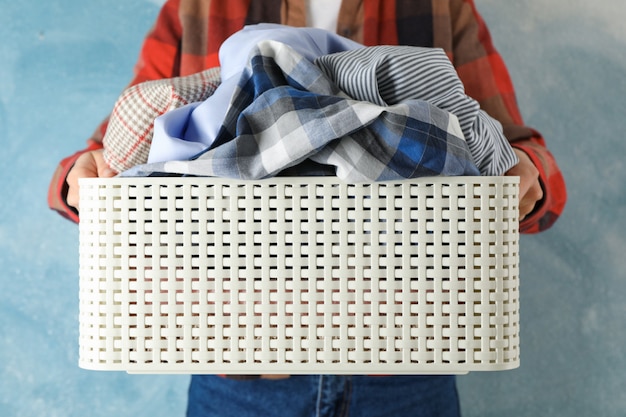 Young woman hold basket with dirty clothes, close up