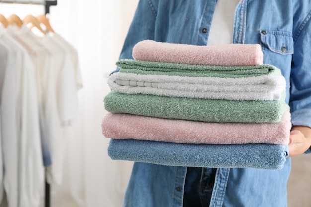 Young woman hold clean towels, close up and