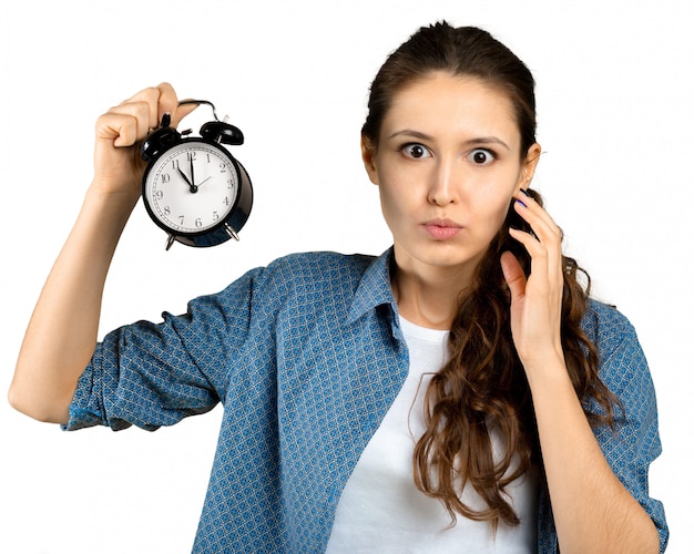 Young woman holding alarm clock