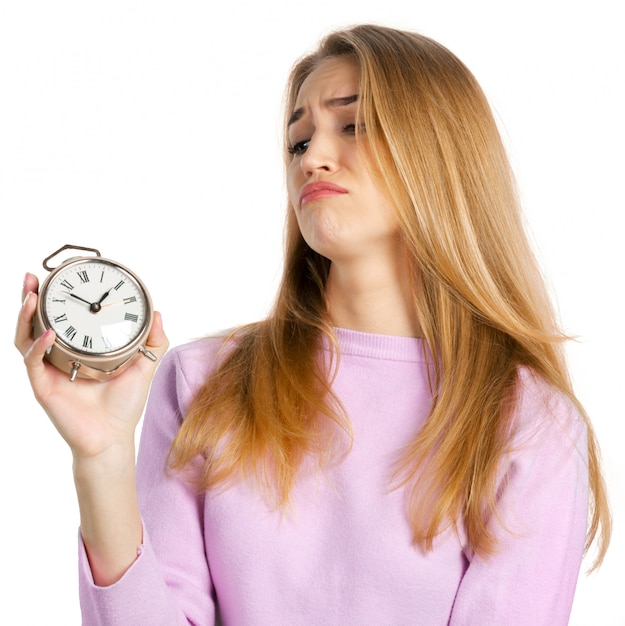 Young woman holding alarm clock