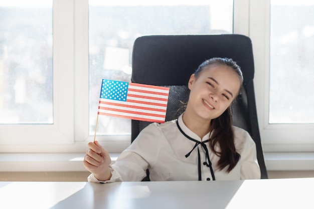 Young woman holding american flag in her hand smiling