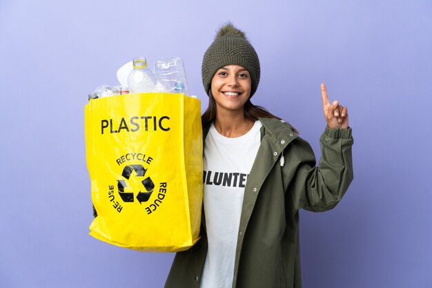 Young woman holding a bag full of plastic pointing up a great idea