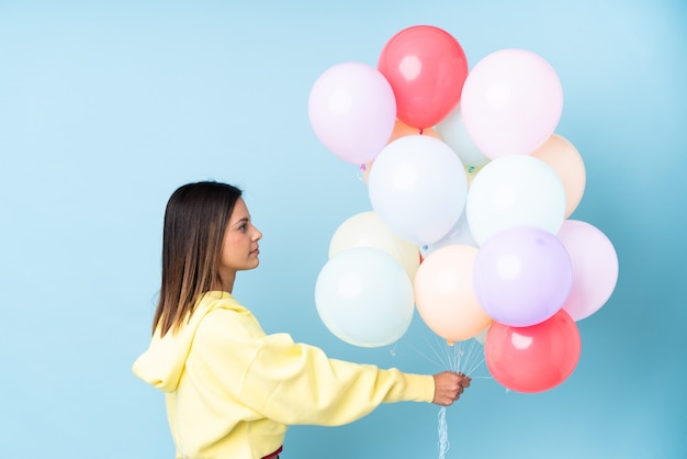 young woman holding balloons over isolated