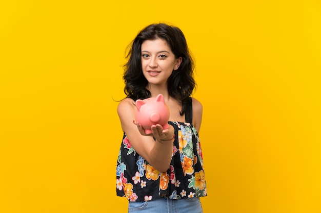 Young woman holding a big piggybank