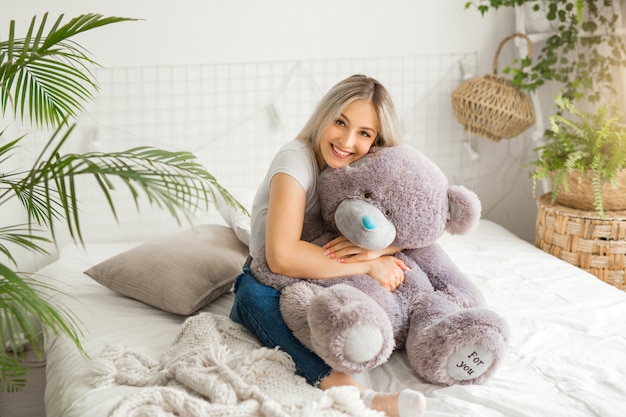 Young woman holding a big teddy bear