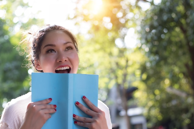 Foto giovane donna con un libro in mano mentre è in piedi nel cortile