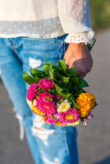 Young woman holding a bouquet of flowers in his hand outside