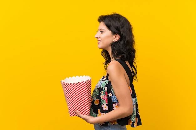 Young woman holding a bowl of popcorns