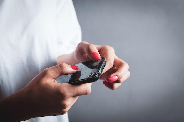 Young woman holding broken phone