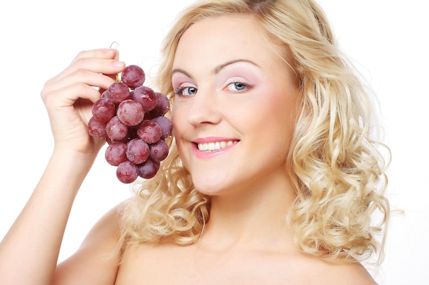 Young woman holding bunch of grapes