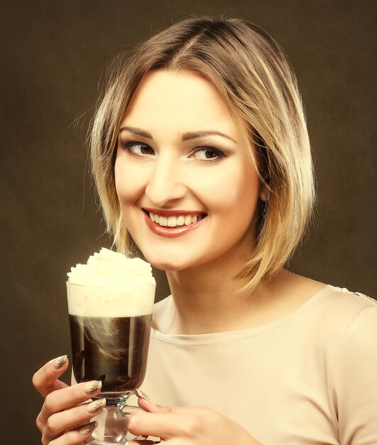 Young woman holding cafe latte cup