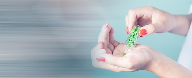 Young woman holding capsules in her hand