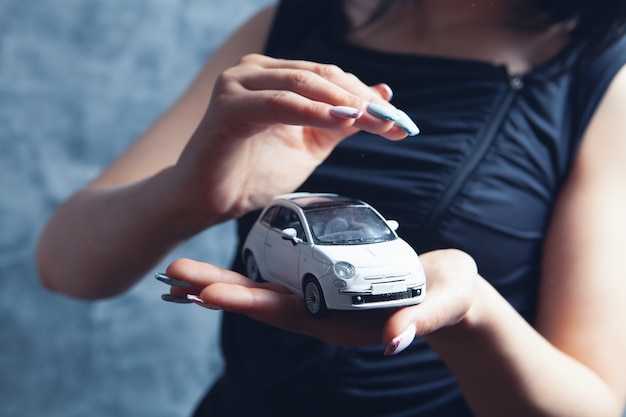 Young woman holding a car