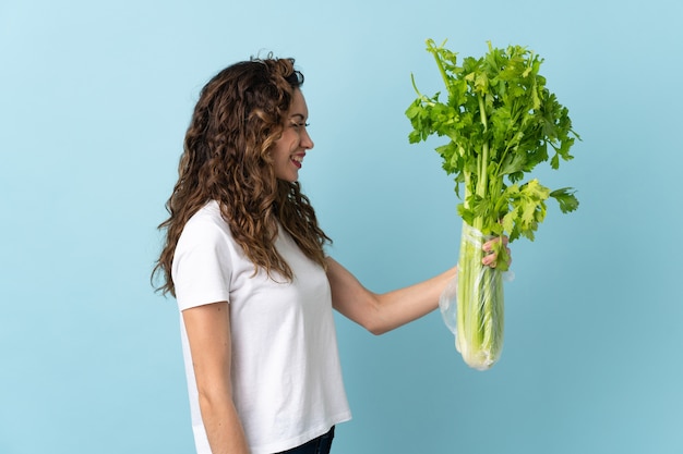 Young woman holding a celery