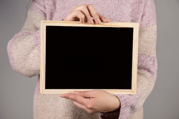 Young woman holding chalkboard