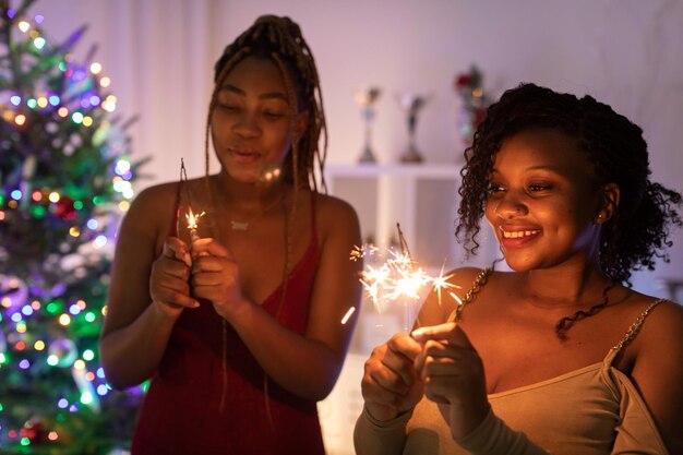 写真 家でクリスマスツリーを掲げている若い女性