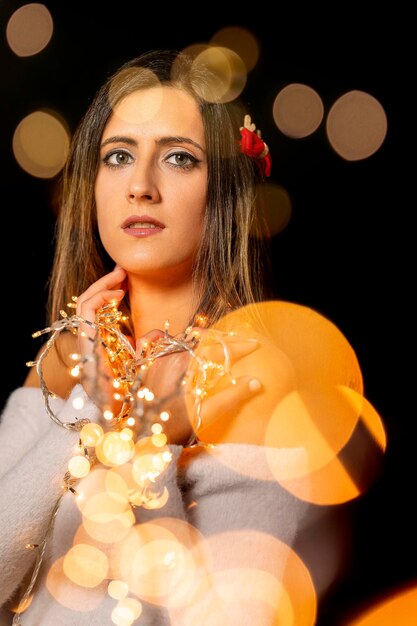 Foto giovane donna con le luci di natale