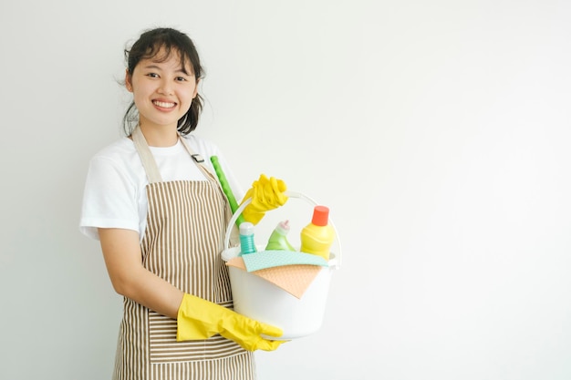 Young woman holding cleaning equipments ready for cleaning