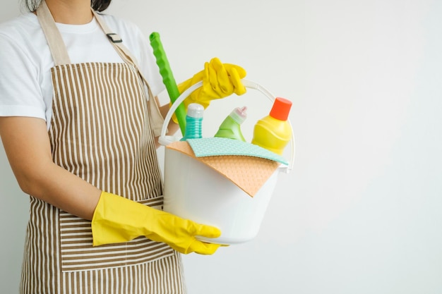 Photo young woman holding cleaning equipments ready for cleaning