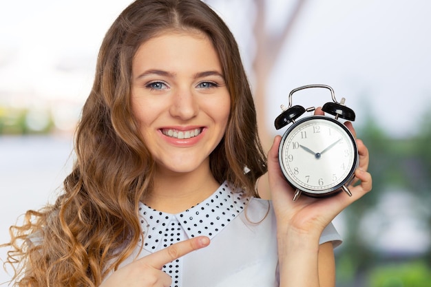 Young woman holding a clock time management concept