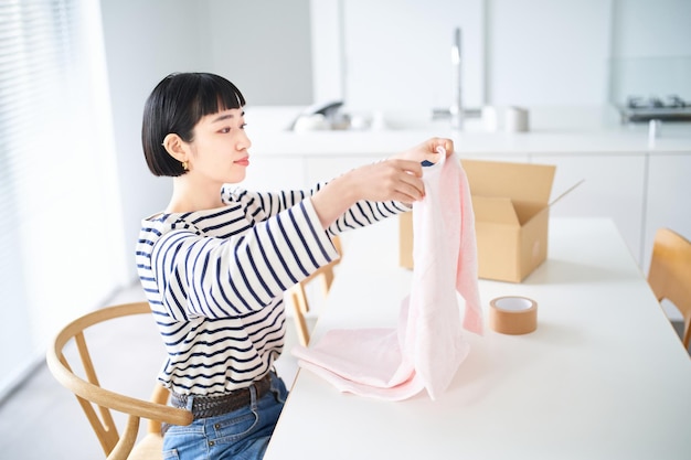 Young woman holding clothes in the room