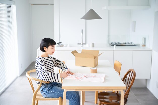 部屋で服を保持している若い女性