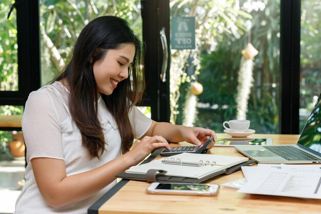 Photo young woman holding coffee while sitting on table at cafe