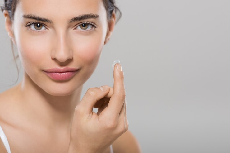 Photo young woman holding contact lens on index finger with copy space