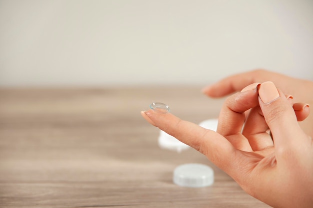 Young woman holding contact lenses