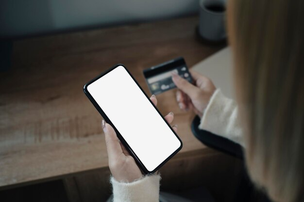 Young woman holding credit card and shopping online with smart phone.