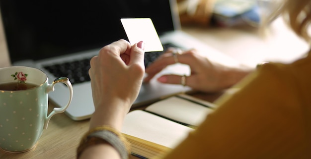 Young woman holding credit card and using laptop computer Online shopping concept