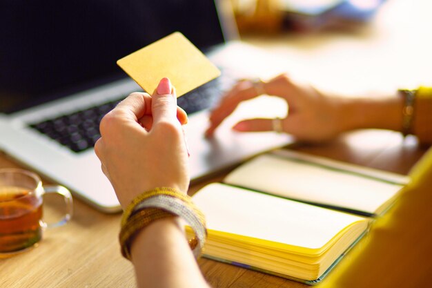 Foto giovane donna che tiene la carta di credito e utilizza il computer portatile concetto di shopping online