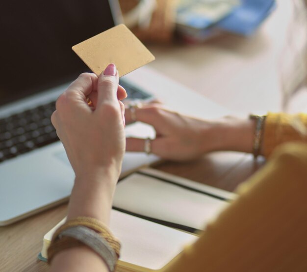 Young woman holding credit card and using laptop computer Online shopping concept