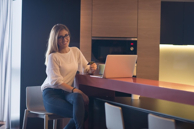 Young woman holding credit card and using laptop computer. Online shopping concept