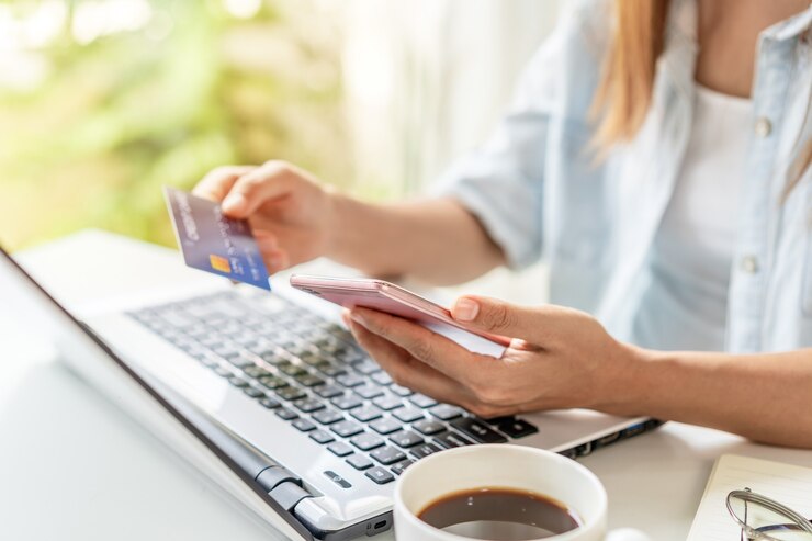 Photo young woman holding a credit card and using smartphone for making online payment shopping