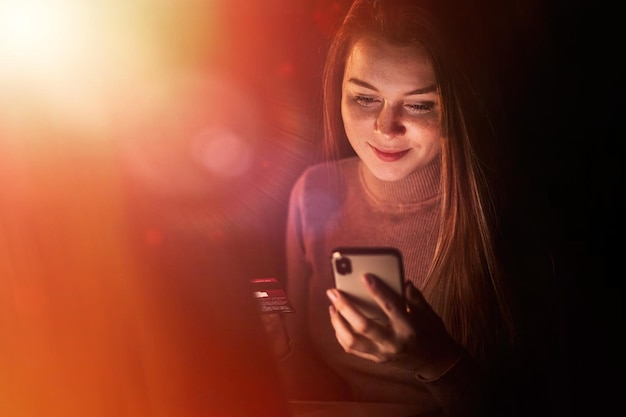 Young woman holding credit card and using smartphone for Online